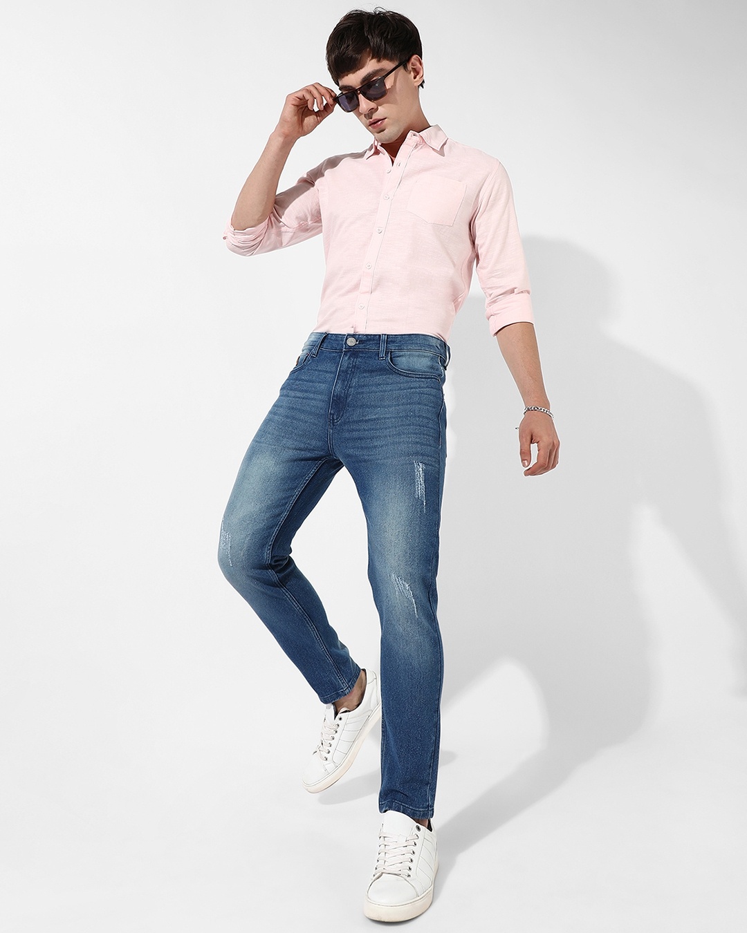 man combined a pink shirt with fitted blue jean  