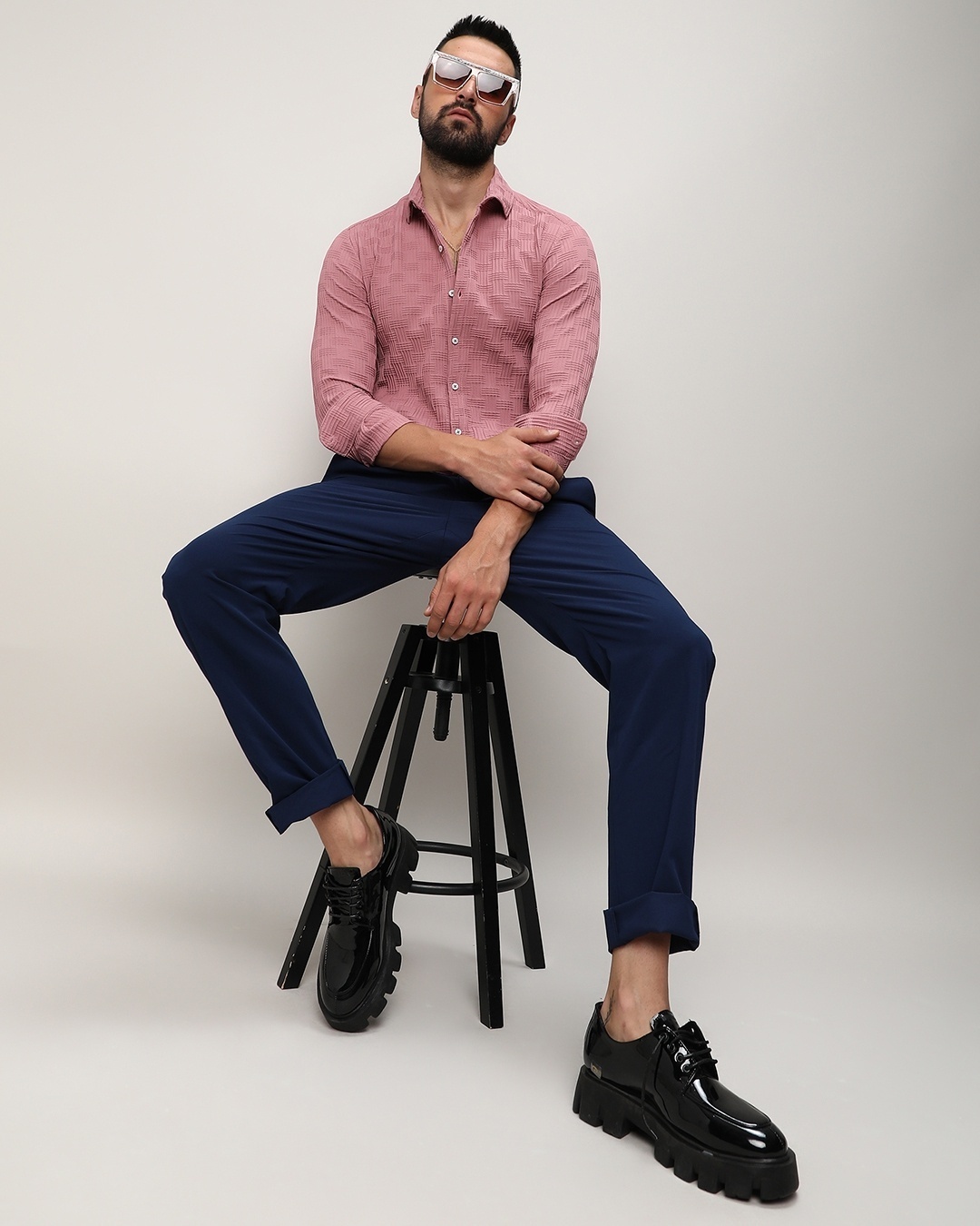 Man wearing textured pink shirt with navy blue pants
