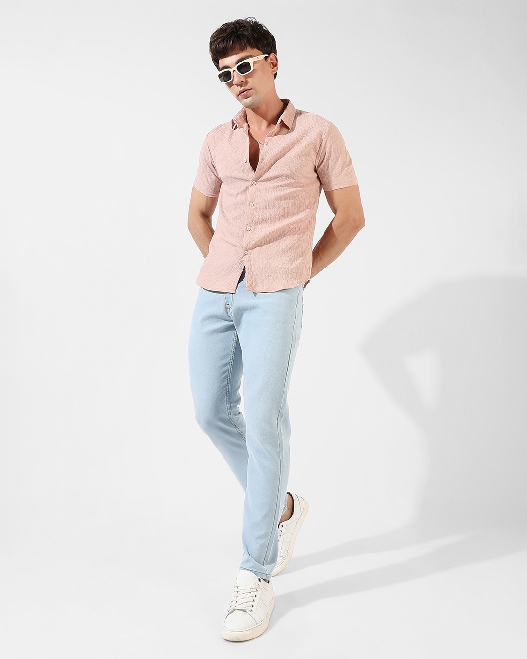 Man wearing pink shirt with light blue jean
