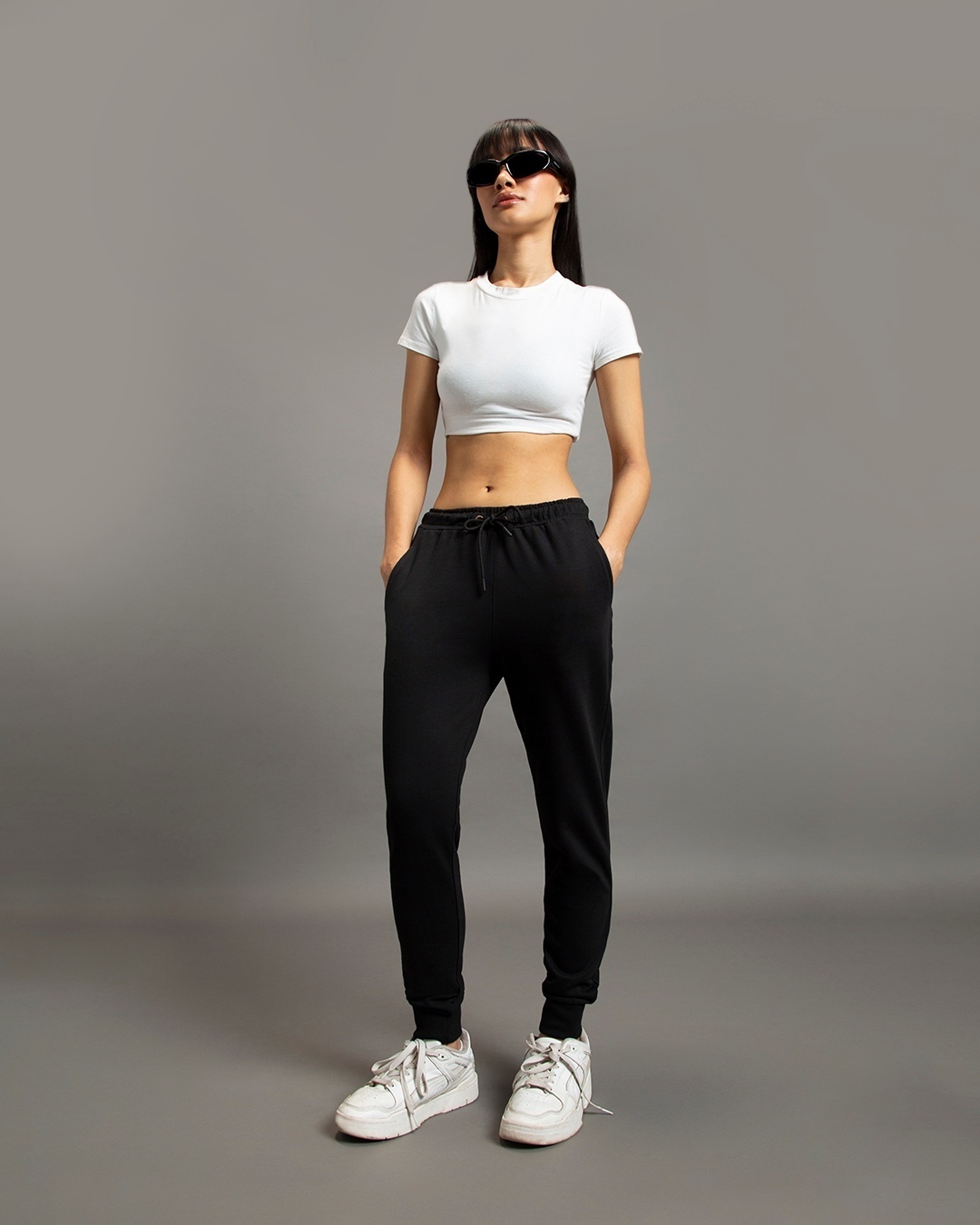 woman styled a black joggers with white top and sneakers