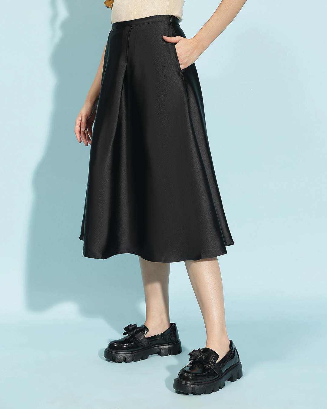 woman styled a skirt with black boots