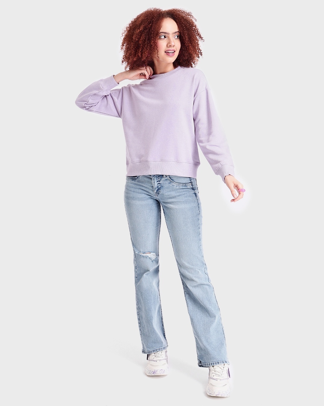 woman styled a sweatshirt with jean and sneakers