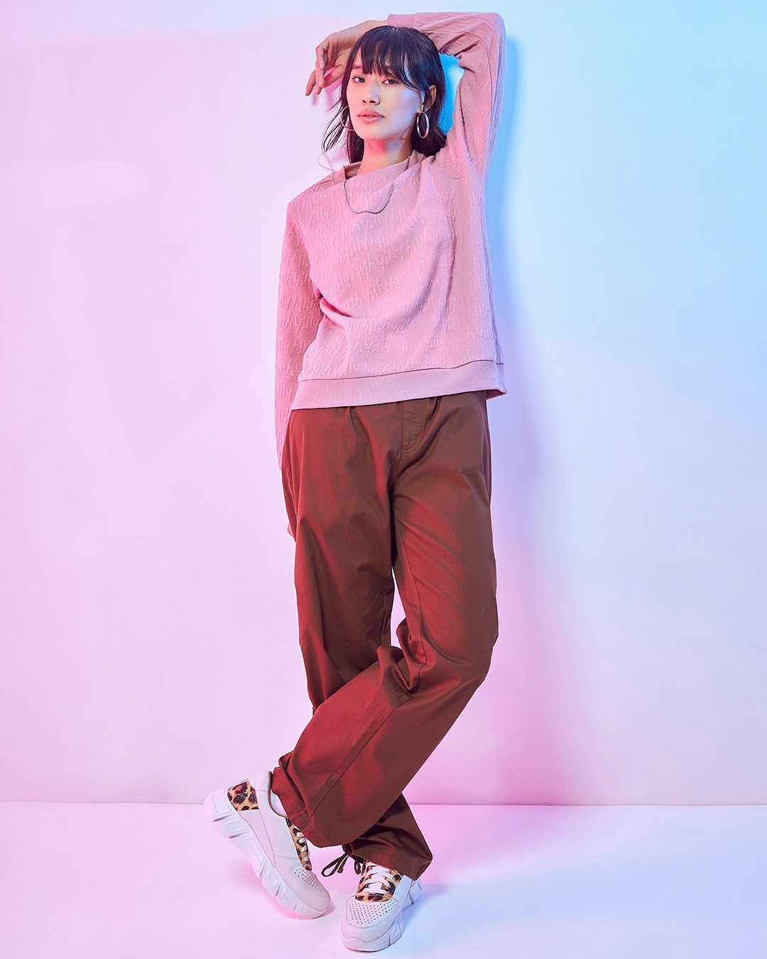 woman styled a pink sweatshirt with pant and sneakers