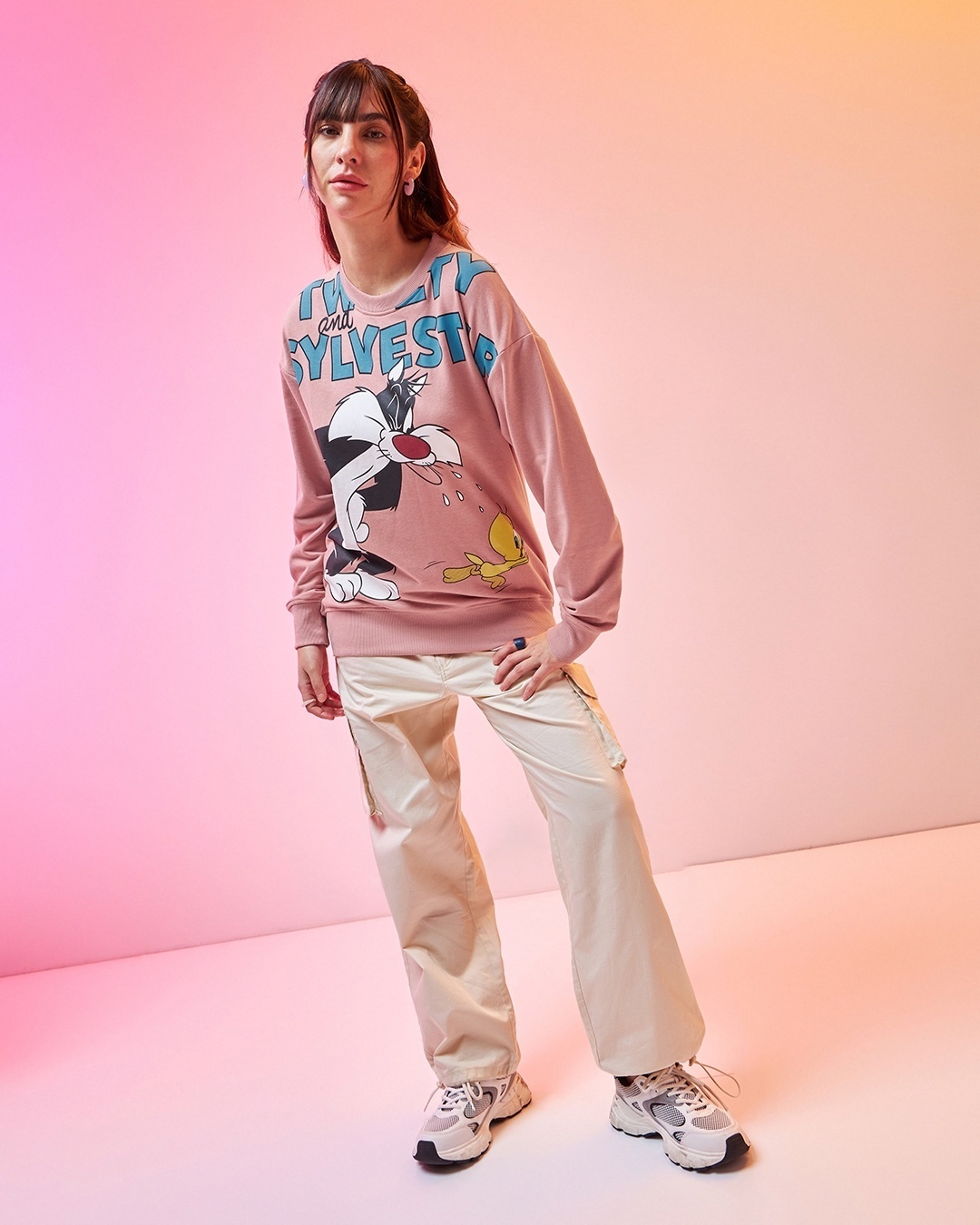 woman styled a pink sweatshirt with pant and sneakers