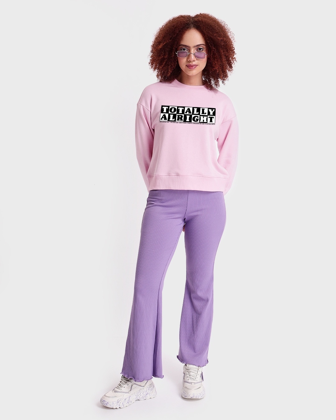 woman styled a pink sweatshirt with pant and sneaker