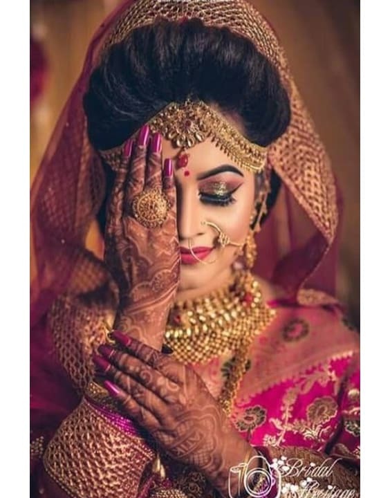 Indian bride posing outdoors on her pink lehenga. | Photo 269220