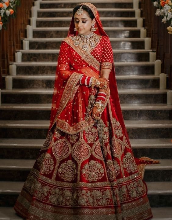 Photo of Bride in red lehenga posing for bridal portrait