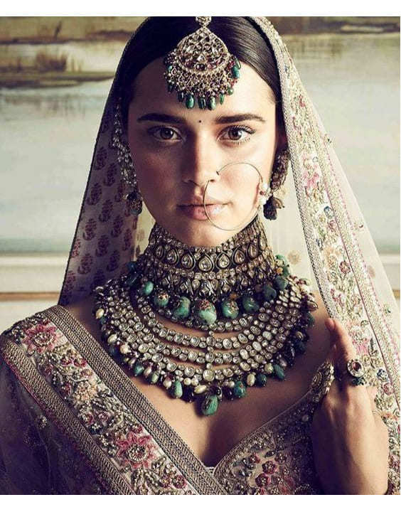 Photo of Bride in red lehenga posing for bridal portrait